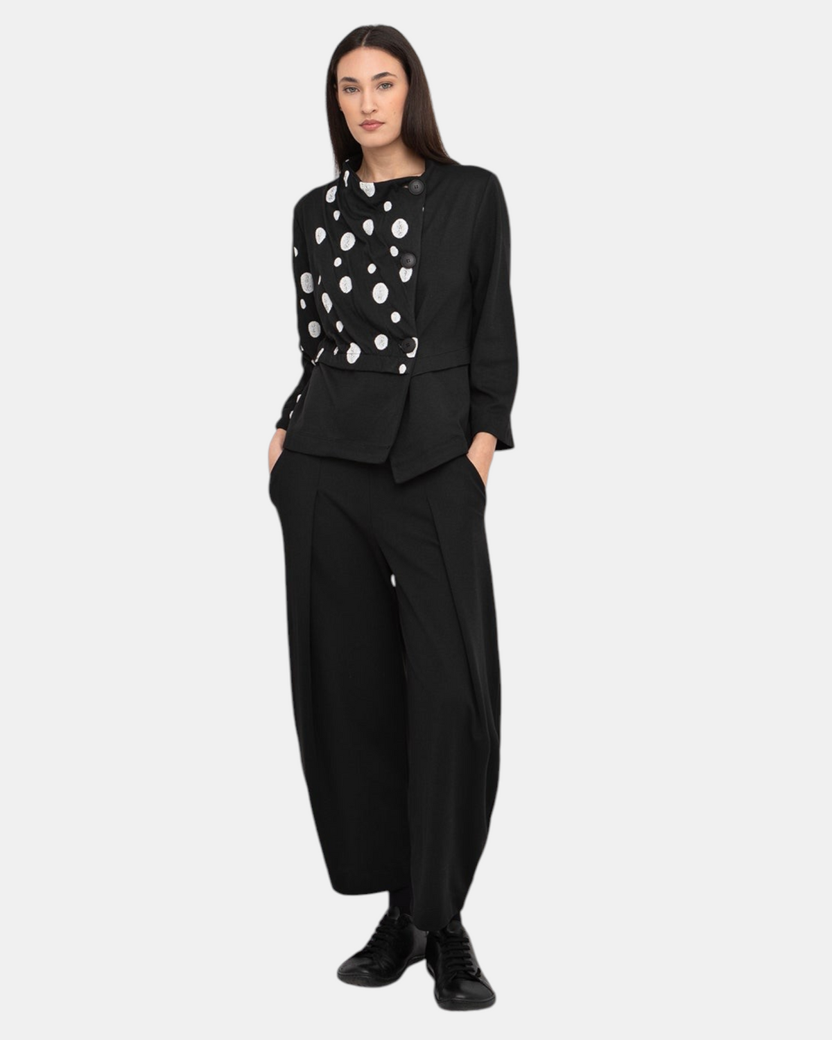 Model trägt eine kurze schwarze Jacke LEEZZA Ozai N Kü GIOIA mit asymmetrischem Knopfverschluss und weißen Punkten.