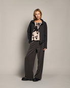 Model wearing LEEZZA AMBER & MOON DORY wide-leg scuba trousers in dark grey with a stretch waistband and side pockets.